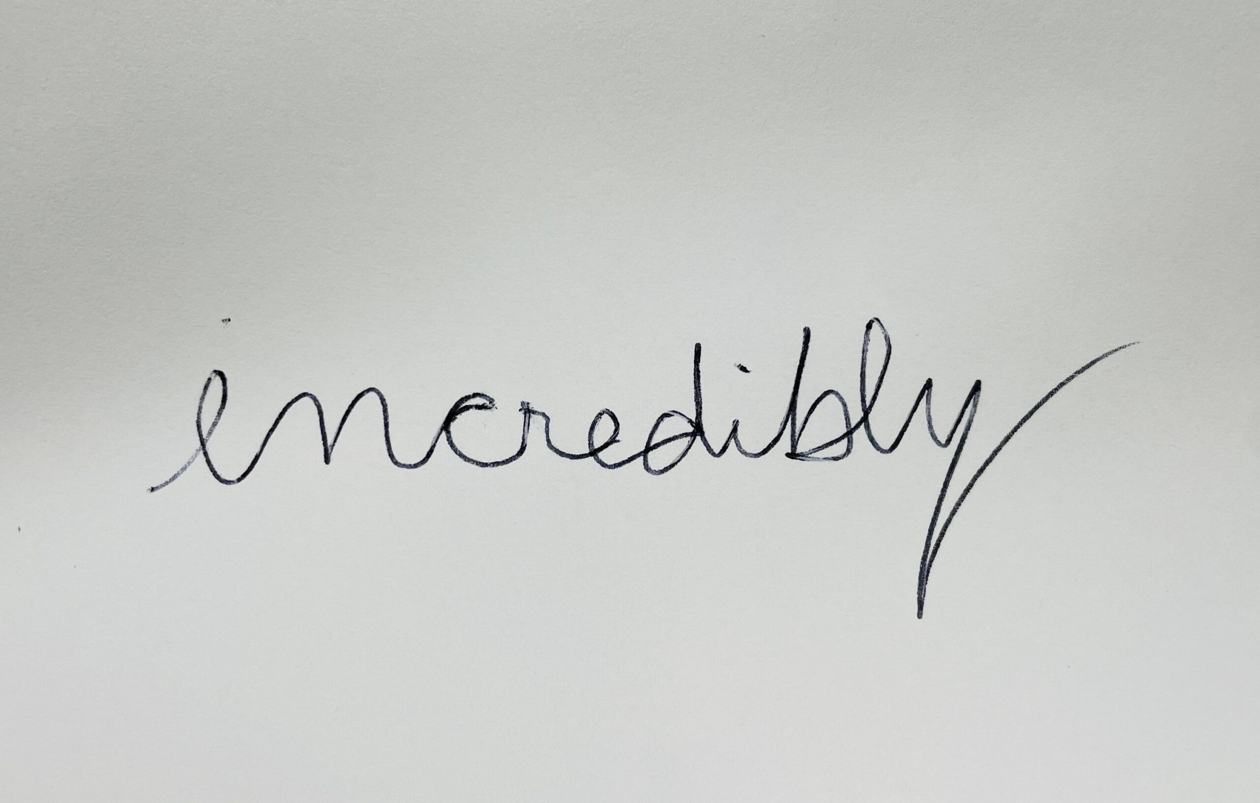 incredibly written in cursive and looks like the word meredibly